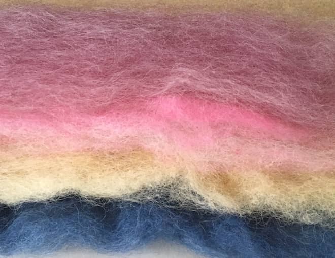 stack of pink cream and blue batts of carded wool