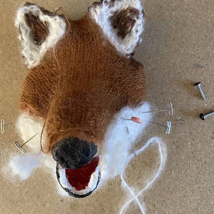 brown and white fox head knitted sculpture with pins in progress by Eve Jacobs-Carnahan