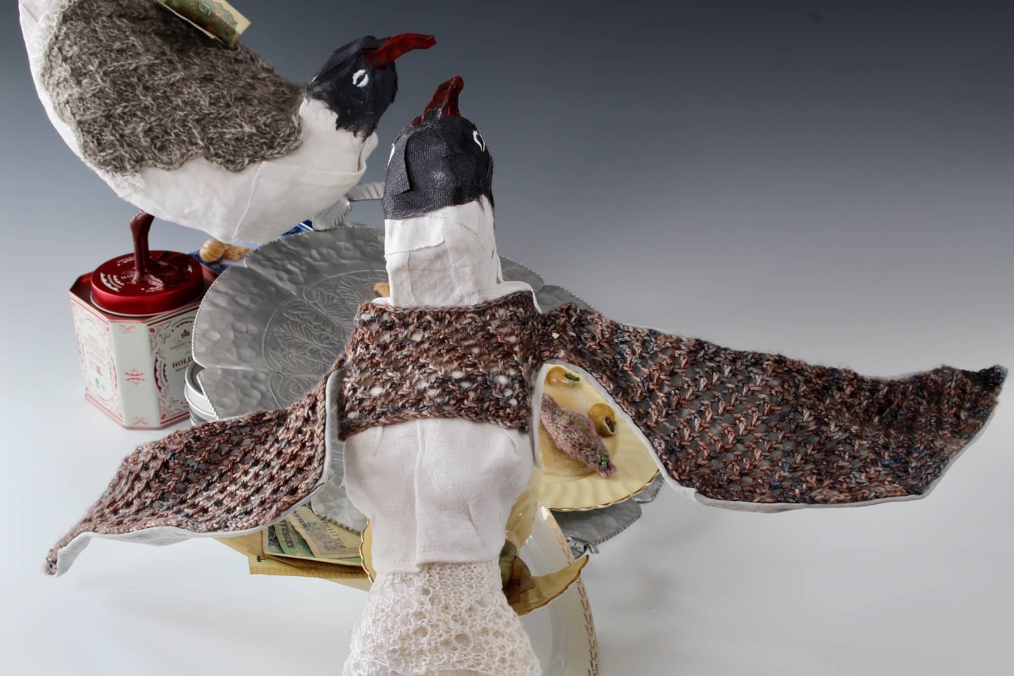 mixed media sculpture of laughing gull with grey knitted lace wings outstretched and white lace tail